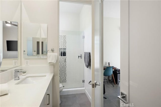 bathroom featuring a shower with door, vanity, tile patterned floors, and toilet