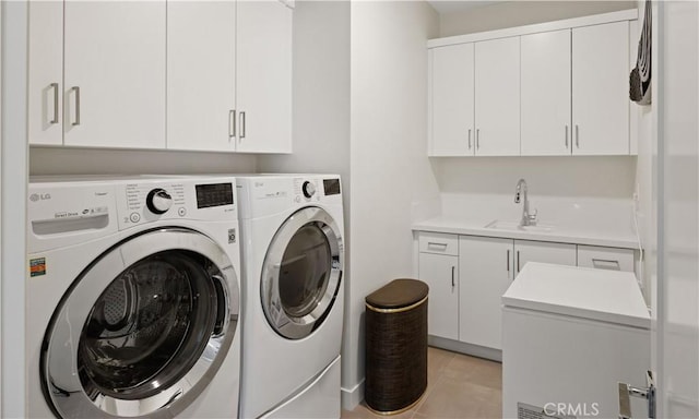 washroom with sink, washing machine and dryer, and cabinets