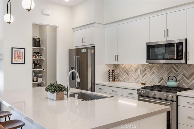 kitchen with white cabinetry, sink, decorative light fixtures, and stainless steel appliances