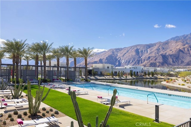 view of swimming pool with a mountain view, a yard, and a patio area