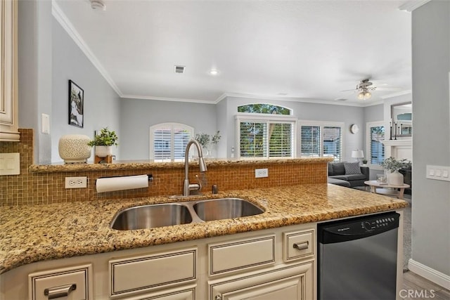 kitchen featuring tasteful backsplash, dishwasher, sink, light stone counters, and cream cabinetry