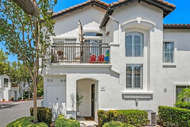 mediterranean / spanish-style house featuring a balcony and central air condition unit