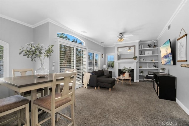 dining space featuring ceiling fan, ornamental molding, and carpet