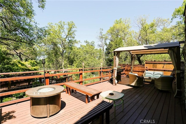 deck with an outdoor living space with a fire pit