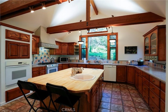 kitchen featuring appliances with stainless steel finishes, tasteful backsplash, sink, vaulted ceiling with beams, and custom exhaust hood