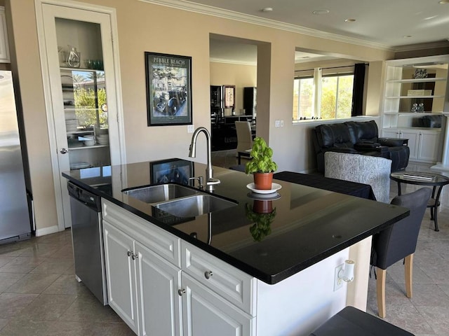 kitchen with sink, appliances with stainless steel finishes, white cabinetry, ornamental molding, and an island with sink