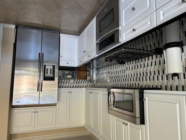 kitchen with white cabinetry, appliances with stainless steel finishes, and backsplash