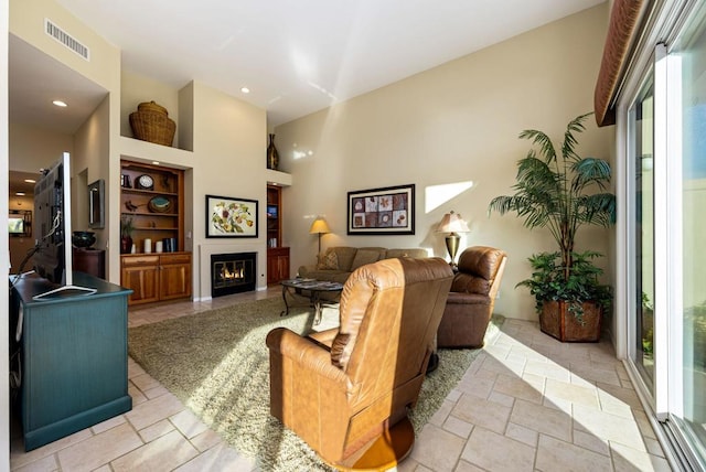 living room featuring a towering ceiling and built in features