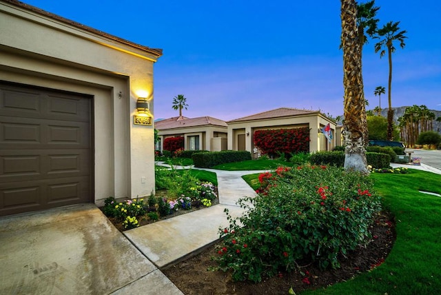 exterior space featuring a garage and a lawn