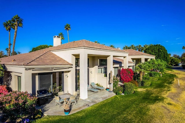 back of house featuring a yard and a patio