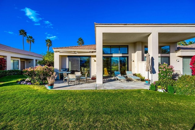 rear view of property with a lawn and a patio area