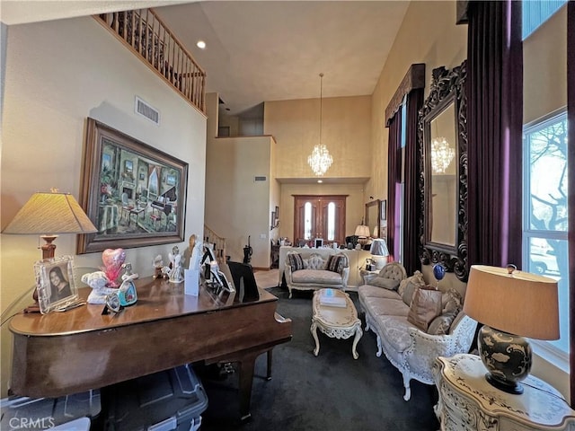 living area with carpet floors, a chandelier, and a high ceiling