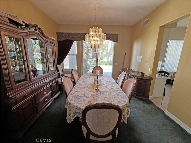 dining room with dark colored carpet and a chandelier