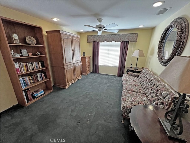 living area featuring ceiling fan and dark carpet