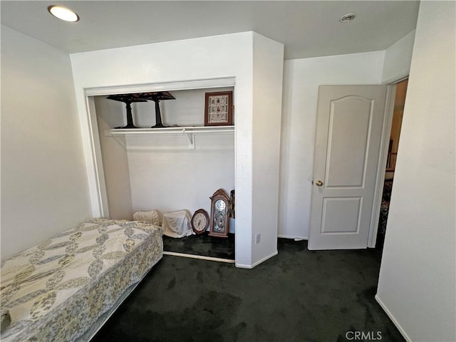 bedroom featuring dark carpet and a closet