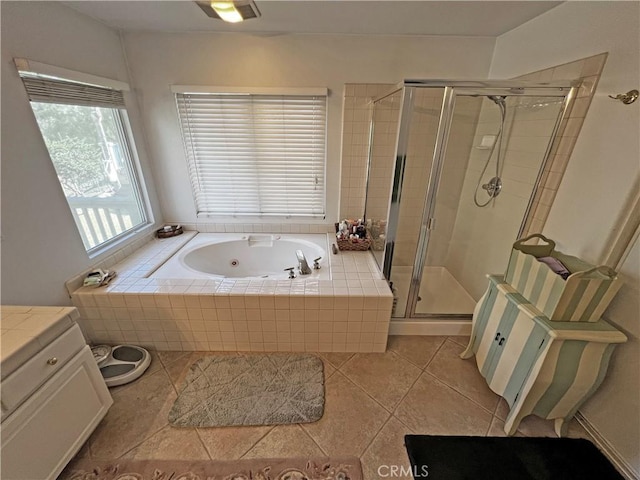 bathroom featuring tile patterned flooring, vanity, and shower with separate bathtub