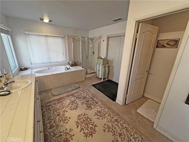 bathroom with tile patterned flooring, vanity, a wealth of natural light, and shower with separate bathtub