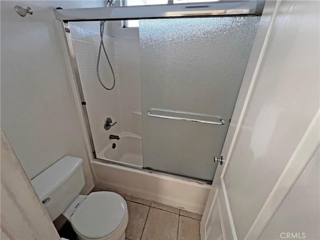 bathroom featuring tile patterned flooring, shower / bath combination with glass door, and toilet