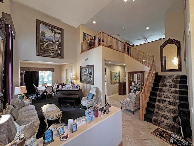 tiled living room with a towering ceiling and a notable chandelier