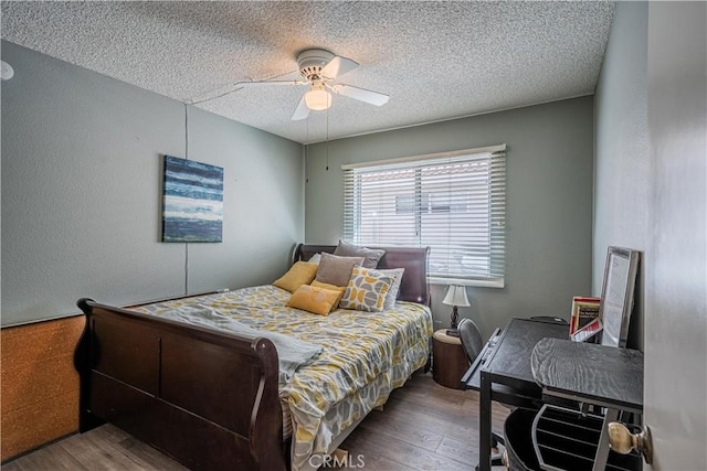 bedroom featuring a textured ceiling, wood finished floors, and a ceiling fan