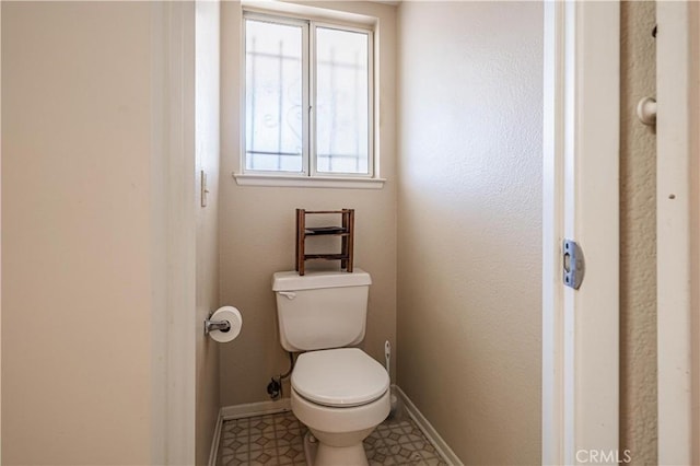 bathroom featuring toilet and baseboards