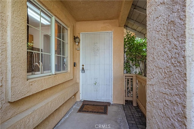 entrance to property featuring stucco siding