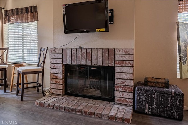 room details featuring a fireplace, wood finished floors, and baseboards