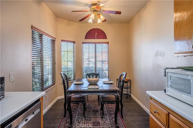 dining space featuring ceiling fan, baseboards, and dark wood finished floors