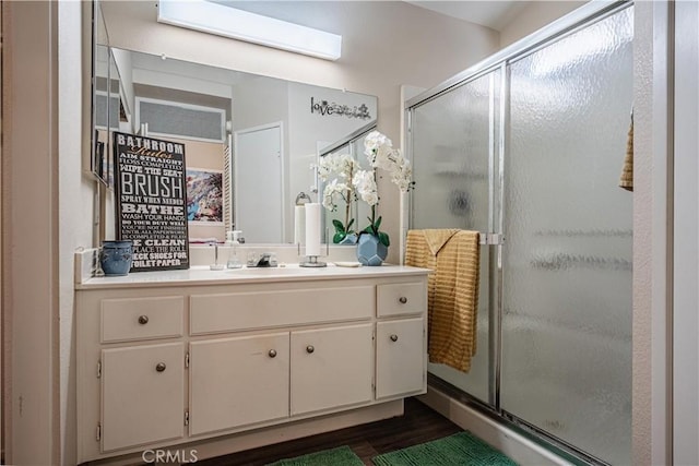 bathroom featuring a stall shower, wood finished floors, and vanity