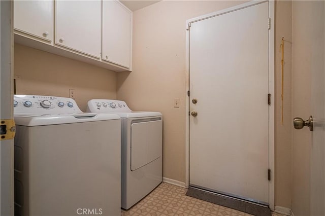 laundry room with light floors, baseboards, cabinet space, and washing machine and clothes dryer