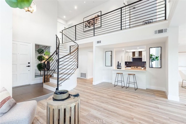 entryway featuring light hardwood / wood-style floors and a high ceiling