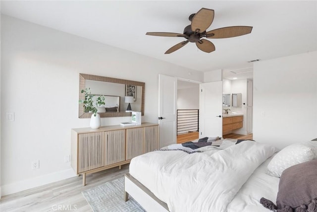 bedroom featuring ceiling fan, ensuite bath, and light hardwood / wood-style flooring