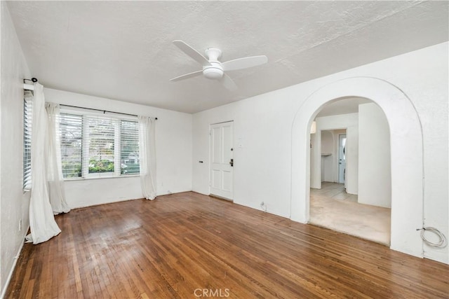 empty room featuring ceiling fan, wood-type flooring, and a textured ceiling