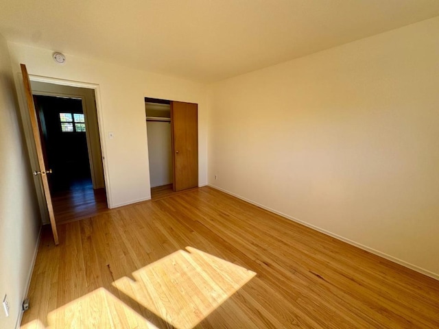 unfurnished bedroom with hardwood / wood-style floors and a closet