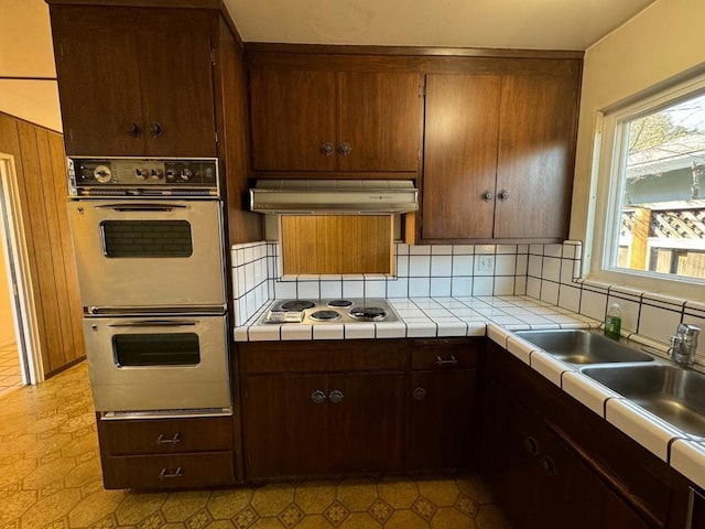 kitchen featuring sink, tile countertops, white appliances, and decorative backsplash