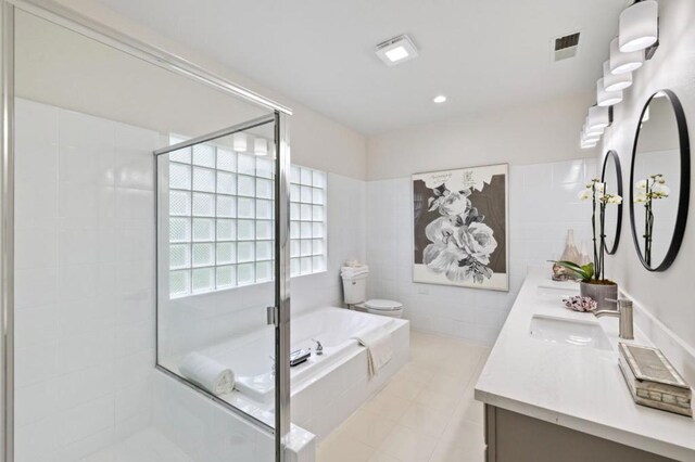 full bathroom featuring shower with separate bathtub, tile walls, vanity, toilet, and tile patterned floors