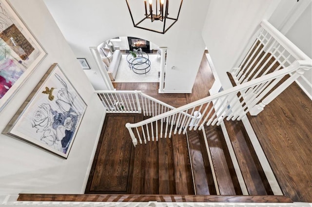 stairs featuring hardwood / wood-style floors and a chandelier