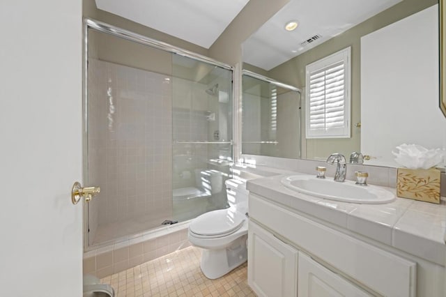 bathroom with vanity, tile patterned floors, a shower with door, and toilet