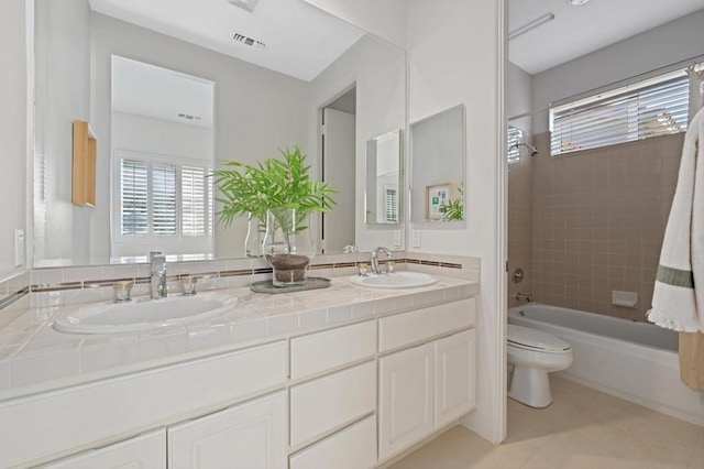 full bathroom with tiled shower / bath, vanity, toilet, and tile patterned flooring