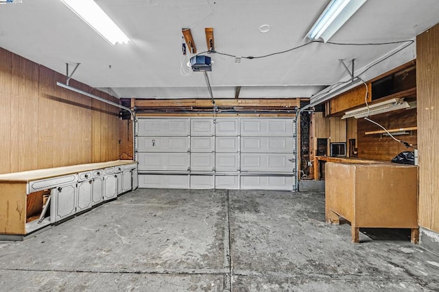 garage featuring a garage door opener and wood walls