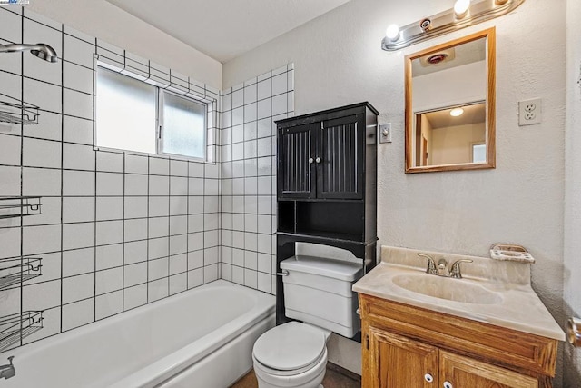 full bathroom with vanity, tiled shower / bath, and toilet