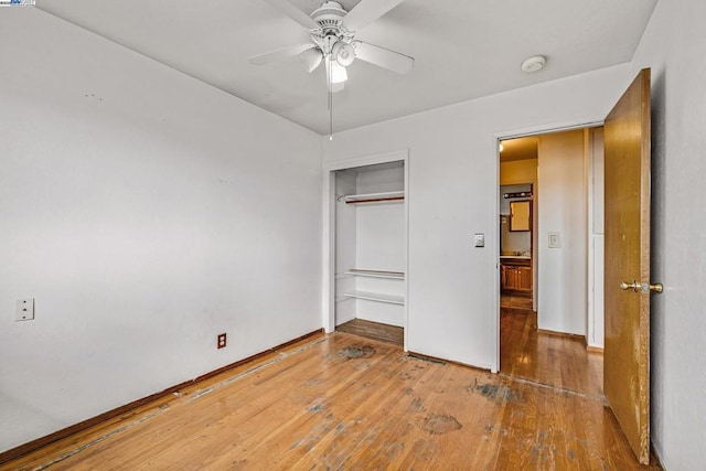 unfurnished bedroom with hardwood / wood-style flooring, ceiling fan, and a closet