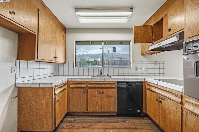 kitchen with sink, tile counters, backsplash, and black appliances