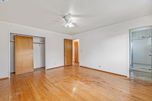 unfurnished bedroom featuring hardwood / wood-style flooring, ceiling fan, ensuite bath, and a closet