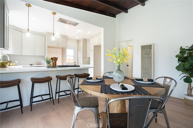 dining room featuring beamed ceiling, dark hardwood / wood-style floors, sink, and wood ceiling