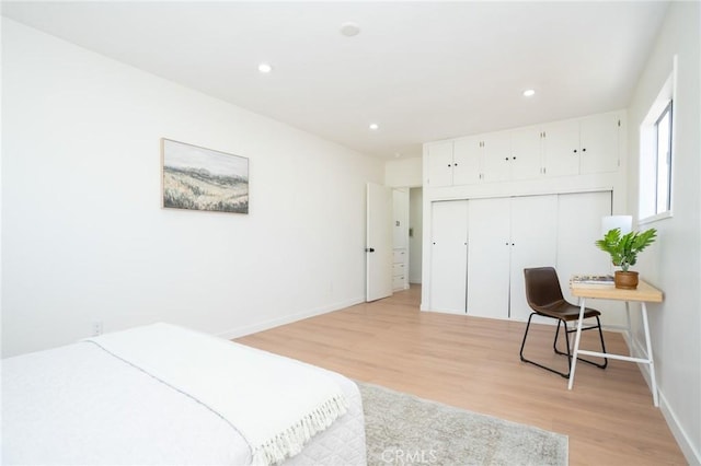 bedroom with light hardwood / wood-style floors and a closet