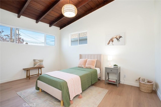 bedroom with lofted ceiling with beams, light hardwood / wood-style flooring, and wooden ceiling