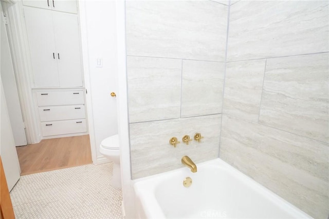 bathroom featuring tiled shower / bath and toilet