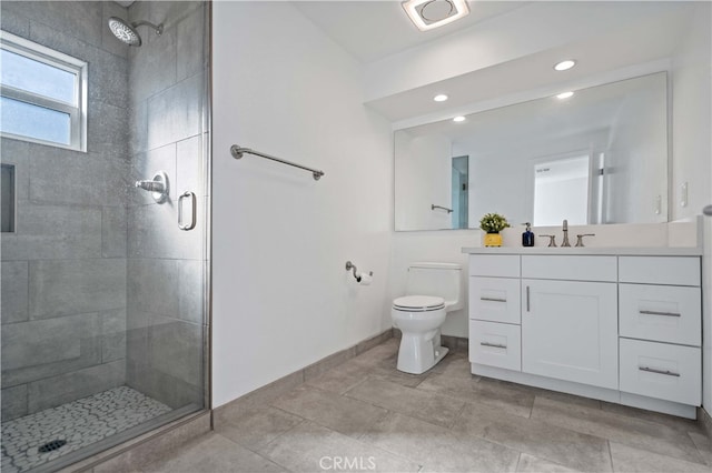 bathroom featuring vanity, tile patterned flooring, toilet, and walk in shower