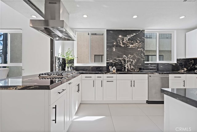 kitchen with sink, white cabinetry, stainless steel appliances, island exhaust hood, and decorative backsplash